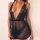 Woman wearing a sheer black polka dot mesh lingerie set with lace detailing and a deep v-neckline.