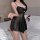Woman wearing black sheer plus size sexy lingerie sleepwear set with floral details, holding a red rose on a bed.