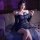 Woman in a plus size sheer one-shoulder bodycon skirt set, posing seductively on a bed with rose petals.