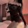 Woman in black sheer one-shoulder bodycon skirt set, holding wine glass in bedroom. plus size sexy office secretary outfit.