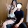 A woman in a schoolgirl maid outfit poses with a man, wearing a police uniform-themed skirt and top. the image features playf...