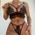 Woman wearing black prilin lace lingerie set with eyelash trim bra and strappy panty, showcasing elegant sleepwear design.