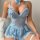 Woman wearing light blue lace lingerie set with bow details and matching fishnet stockings, elegant european-style sensual un...