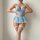 Woman modeling light blue lace lingerie set with matching fishnet stockings, featuring sheer bodice and flared skirt.