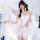 A woman poses elegantly in a white sheer ballet-inspired lingerie dress, featuring delicate lace and angel wings, perfect for...