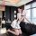 A woman poses elegantly in a modern living room, wearing a white chinese-inspired sleep dress. the dress features high neckli...