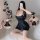 A woman poses in a black cami dress with a backless design, showcasing its sheer lace details. the dress features spaghetti s...