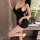 Woman wearing black pure & alluring lace-back sleepwear set – premium ice silk sensual pajamas with adjustable ties, posing e...