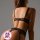 Woman wearing black lace lingerie set with floral embroidery, featuring a strapless bra, thong, and garter belt.