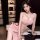 Woman in pink lace sleep dress with high slit, sheer sensual lounge wear for intimate evenings.