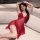 A woman poses elegantly in a sheer red lace sleep dress with a front clasp design, perfect for romantic nightwear.