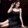 Woman in black sheer slip dress with high slit, holding a pink flower, elegant lounge wear for women.