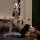 Woman in pure & alluring lingerie set with bunny ears, lace blindfold, and garter stockings posing seductively on a table.