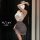 Woman wearing pure & alluring lingerie set – white lace top with gray ruched skirt, posing seductively for date night.