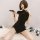 A woman poses elegantly in a black vintage-inspired qipao dress featuring side slits and a bodycon fit, perfect for modern el...
