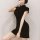 A woman poses in a black vintage-inspired qipao dress featuring side slits and a bodycon fit, perfect for modern elegance.