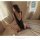 Woman in black open-crotch bodysuit with elegant cutouts, sitting on bed by window. sheer ice-silk lingerie set for seductive...