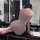 A woman sits on a bathroom counter wearing a sheer purple halter dress with ruched details, showcasing its form-fitting desig...