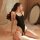 A woman poses elegantly in a black open-crotch ice-silk slip dress, highlighting its sexy design and luxurious fabric. the el...