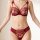 Woman wearing a red lace bra and matching panties. the set features sheer floral embroidery, underwire cups, and bow-tie shou...