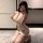 Woman kneeling in a white sheer mesh lace cami sleep dress with deep v-neck and adjustable straps.