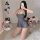 Woman kneeling on white rug in gray silk-look babydoll nightgown with backless design, sheer lace trim, and flared skirt — se...