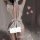 Back view of woman in white lace-trimmed maid-style lingerie set with bow, sheer fabric, and thigh-high stockings.