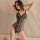 Woman wearing black sheer lace bodysuit with open-crotch design, posing on bed — perfect for date night allure.