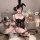 Woman in black lace bunny costume with floral trim, sheer cutouts, and open chest design, posing with whip and balloons.