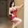 Woman wearing red lace sleep dress, sheer tempting lingerie for women, seductive no-remove nightwear in bedroom setting.