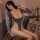A woman poses elegantly wearing a gray micro swimsuit with deep v-neckline and long sleeves, featuring lace trimmings and cut...