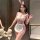 A woman poses in a playful bunny maid costume, featuring a sheer mesh bodice and bunny ears, perfect for role play and flirty...