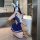 A person wearing a navy blue schoolgirl-style bunny girl outfit, featuring an open-crotch swimsuit skirt and bunny ears, hold...