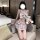 Woman in pure & playful jk sleepwear set, sensual roleplay lingerie with plaid skirt and bow top, holding a teddy bear.