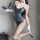 A woman poses wearing a sleek, dark green bodysuit with an open crotch design, paired with fishnet stockings and bunny ears h...