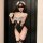Woman wearing pure & playful lingerie set - elegant maid outfit with lace details, blindfold, and thigh-high stockings.