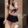 Woman modeling a white lace bra with navy ribbon and matching pleated skirt, part of the pure & playful lingerie set - seduct...