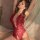Woman wearing red lace bodysuit from pure & playful lingerie set, featuring hip-hugging skirt and seductive design.