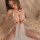 A woman models the pure & playful lingerie set, featuring a delicate white design with lace detailing and sheer fabric, perfe...