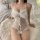 Woman in white lace lingerie set with bow details, sitting on fluffy rug. pure & playful lingerie set - seductive naughty uni...