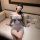 Woman in gray off-shoulder lingerie dress with lace trim and eye mask, seated on sofa — pure & playful lingerie set.