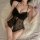 Woman wearing black lace pure & playful lingerie set, seductive uniform-style sleepwear with bow detail and sheer panels.