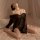 Woman wearing black sheer lingerie set with off-shoulder design, styled as seductive qqny uniform-inspired sleepwear on bed.