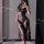 Woman wearing black lace lingerie set with sheer silk robe, seductive sleepwear style for romantic evenings.