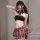 Woman modeling pure & playful lingerie set: red plaid pleated mini skirt, matching halter top with bow, schoolgirl style.