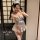 A woman poses in a maid-themed lingerie set, featuring a plaid top with lace details and a matching skirt, perfect for playfu...