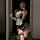 Woman wearing black and white maid lingerie set with lace trim, thigh-high stockings, and choker, taking a mirror selfie.