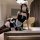 A woman poses in a luxurious room wearing a black and white maid costume sleepwear set from pure & playful. the outfit featur...