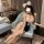Woman in pure & playful lingerie set - sexy maid costume with sheer mesh sleepwear, sitting elegantly on a blue armchair.
