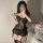 Woman in black lace corset vest lingerie set holding feather wand, minimalist sexy sleepwear with garters and stockings.